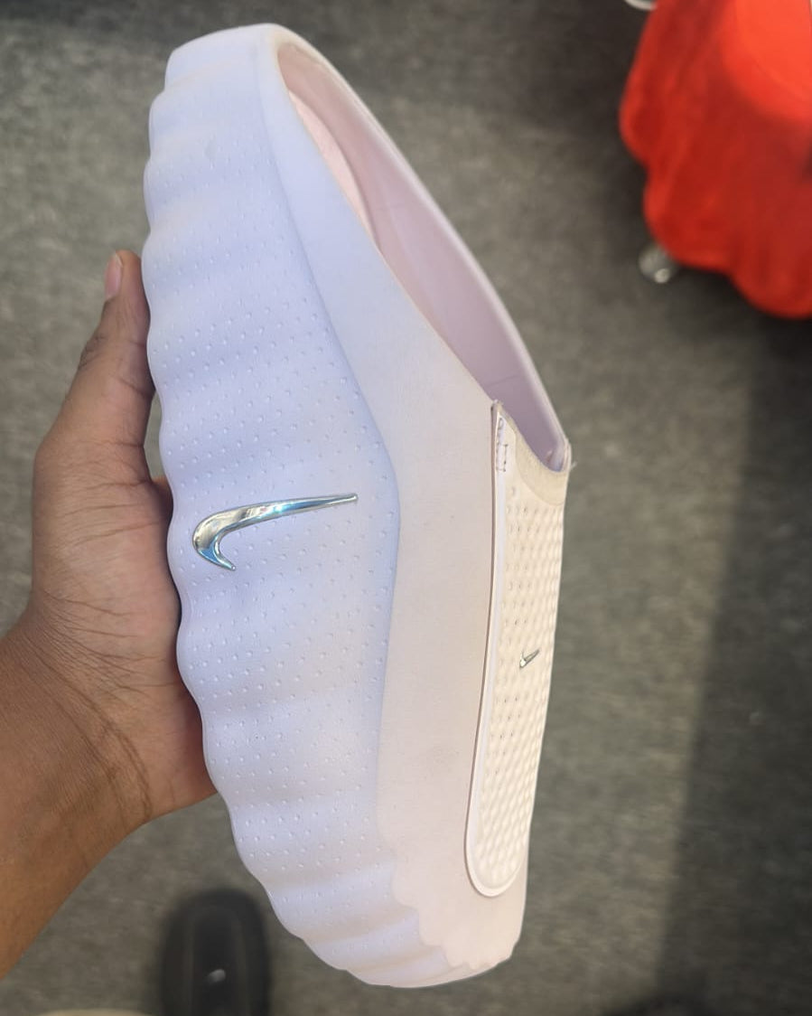 Nike Mind 001 slide in pearl pink with Nike branding, featuring a comfortable strap and textured sole for casual wear.