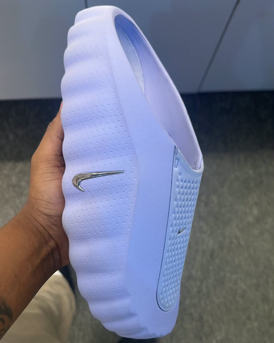 Nike Mind 001 sneakers in white, featuring sleek design and Nike branding, displayed on a clean background.