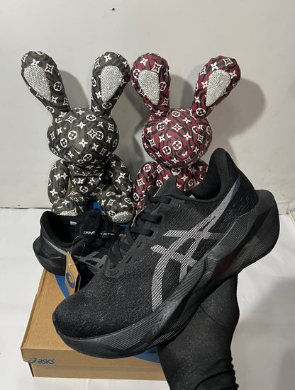 Black ASICS NOVABLAST 6 running shoes with mesh upper and cushioned sole, displayed on a neutral background.