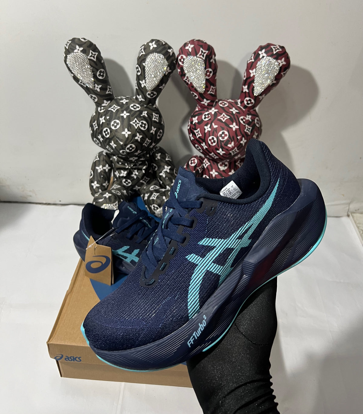 ASICS NOVABLAST 6 running shoes in Midnight and Energy Aqua with breathable mesh uppers and cushioned midsoles.