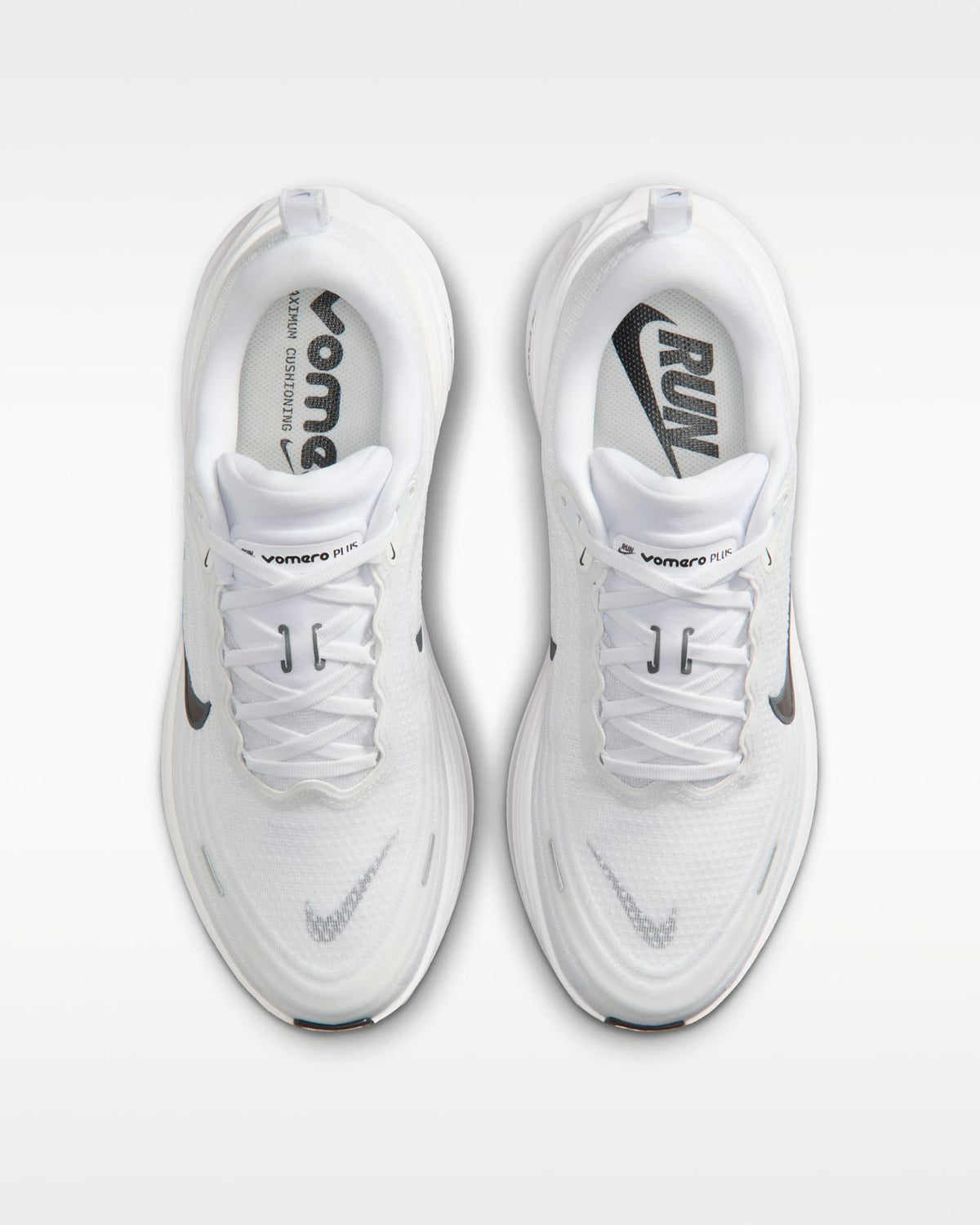 Nike Vomero Plus white running shoes with breathable mesh and cushioned soles, designed for comfort and performance.